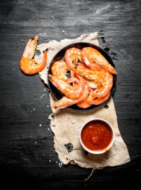 Eski kumaş üzerine domates soslu karides.