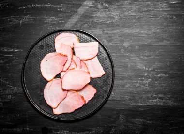 Tabağına dilimlenmiş jambon dilimleri.