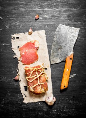 eski kumaş üzerine bir balta ile jambon parçası.