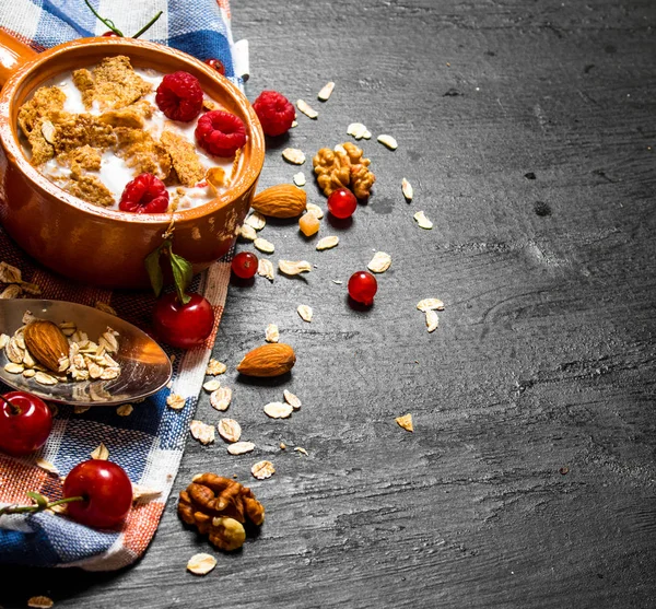 Meyveler, fındık ve kabın içinde süt ile müsli.