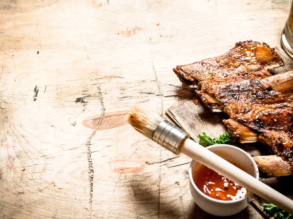 Costelas de porco defumadas com molho picante e uma escova . — Fotografia de Stock