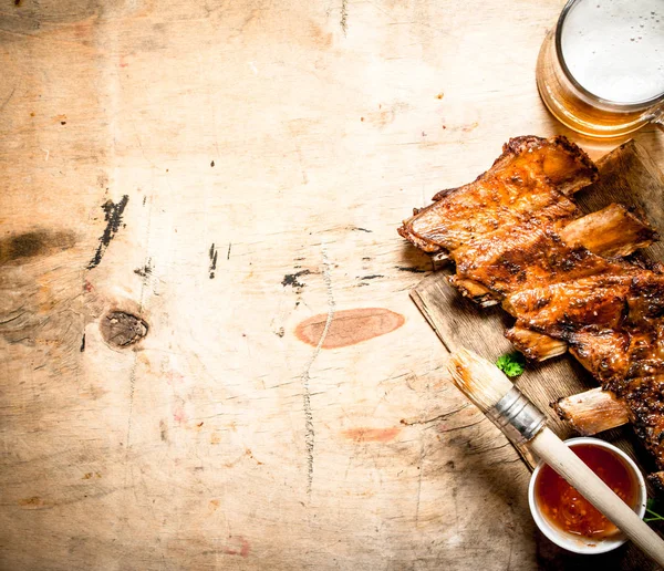 Barbecue pork ribs with tomato sauce and beer. — Stock Photo, Image