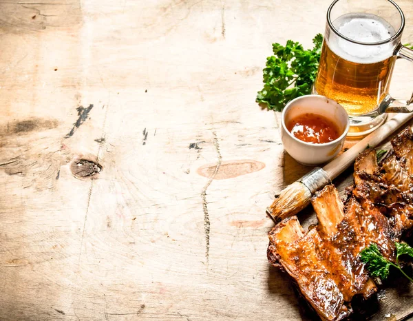 Barbecue pork ribs with tomato sauce and beer. — Stock Photo, Image