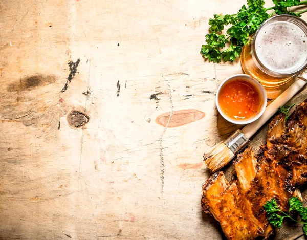 Barbecue pork ribs with tomato sauce and beer. — Stock Photo, Image