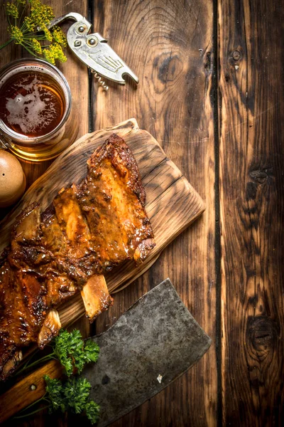 Domuz kaburga ızgara et balta ve bira ile.