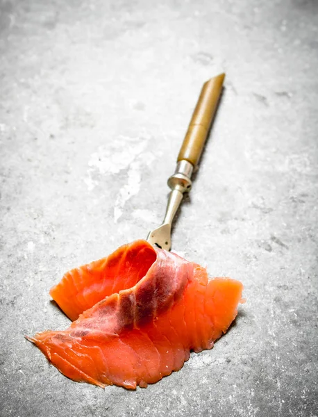 Rodajas finas de salmón ahumado con tenedor . Fotos de stock libres de derechos