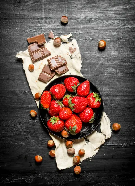 Strawberries with slices of chocolate and nuts. — Stock Photo, Image