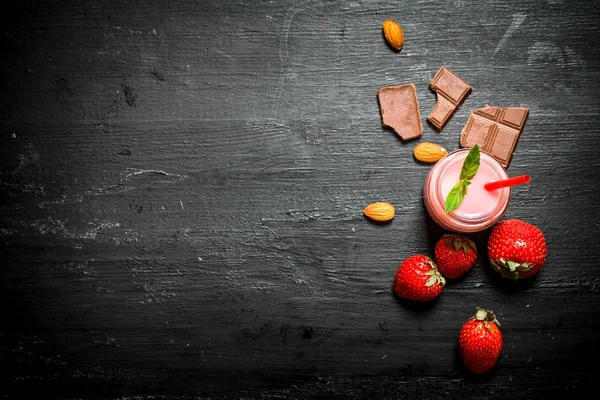 Smoothie de morango com bagas, fatias de chocolate e amêndoas . — Fotografia de Stock