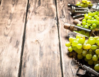 Beyaz bir tirbuşon ve dalları üzüm şarap.