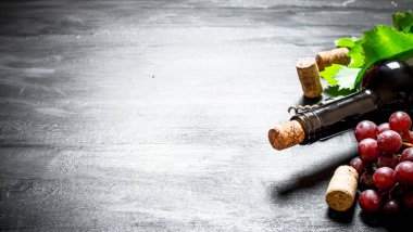 Kırmızı şarap mantarlar ve üzüm bir dalı ile.