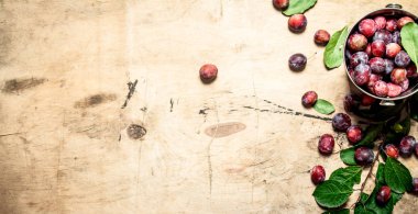 Fresh plums with green leaves.