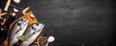 Bir şişe şarapla iki taze balık.