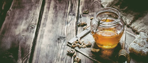 Dolce miele nel pettine, vaso di vetro con noci . — Foto Stock