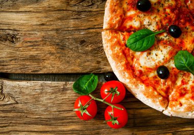 Lezzetli pizza, domates ve diğer malzemeler.