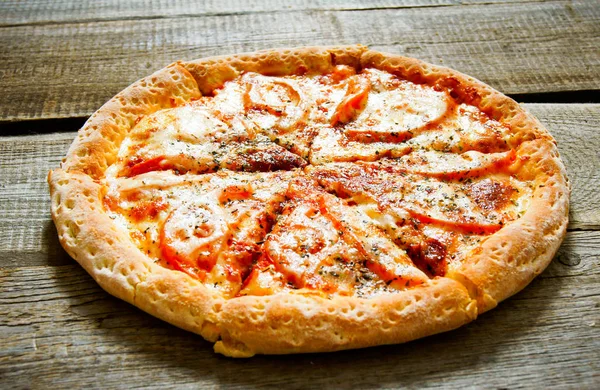 Chutná pizza na dřevěném pozadí. — Stock fotografie