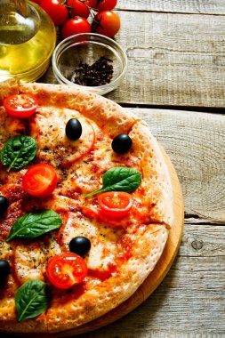 Lezzetli pizza, domates ve diğer malzemeler.