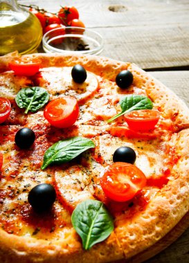 Lezzetli pizza, domates ve diğer malzemeler.