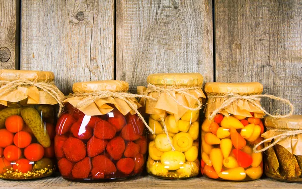 Aliments conservés dans des bocaux en verre, sur une étagère en bois . — Photo