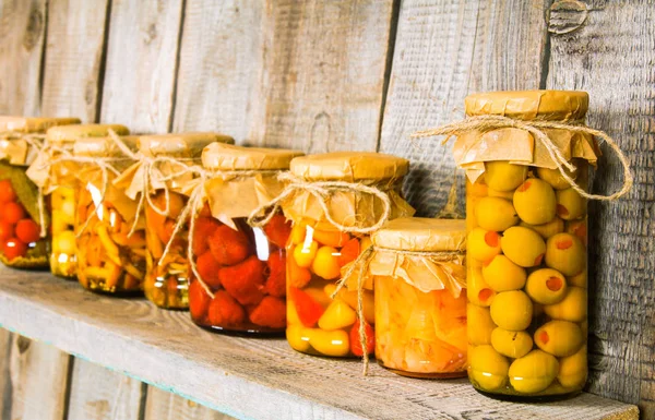 Aliments conservés dans des bocaux en verre, sur une étagère en bois . — Photo