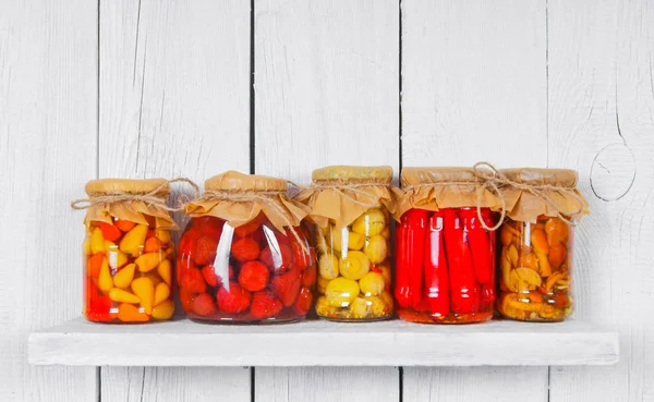 Aliments conservés dans des bocaux en verre, sur une étagère en bois — Photo