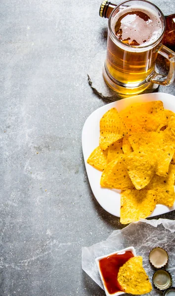 Cerveza con papas fritas y ketchup. Sobre fondo de piedra vieja . — Foto de Stock