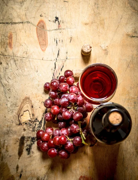 Красный виноград с бутылкой вина . — стоковое фото
