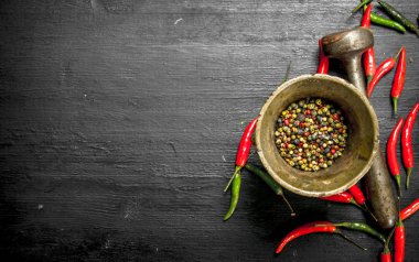 Bir havan topu bir havaneli ile acı biber tanesi.