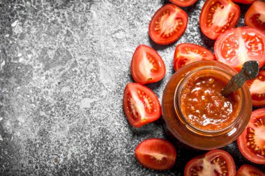 Domates sosu kaşık ile cam kavanoza.