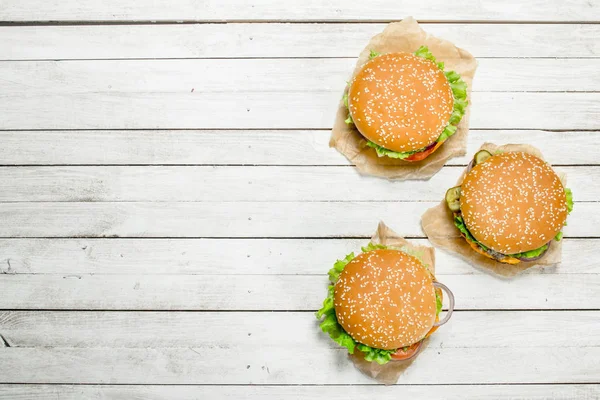 Hamburguesas con carne de res, queso y verduras sobre papel . —  Fotos de Stock