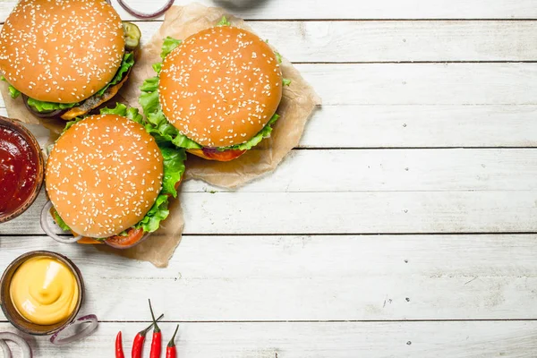 Hambúrgueres com carne fresca, queijo e legumes . — Fotografia de Stock