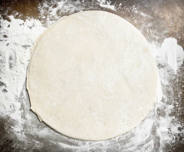 Roll out dough for pizza.