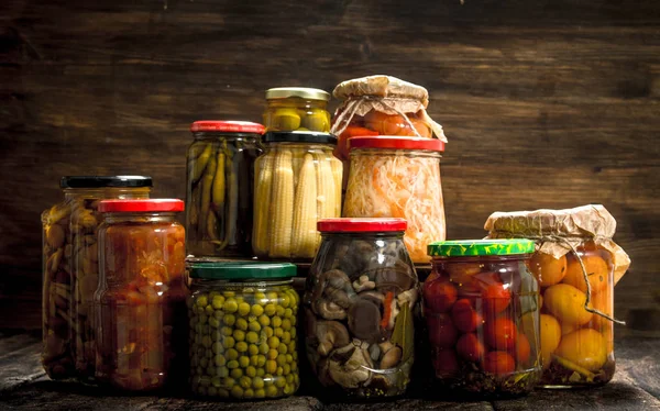 Preserva legumes e cogumelos em frascos de vidro . — Fotografia de Stock