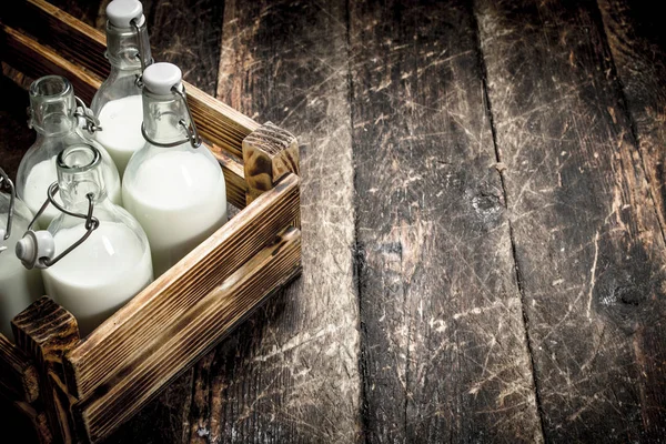 Flaskor med färsk mjölk i en låda. — Stockfoto