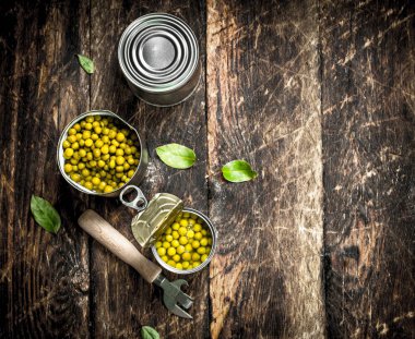 Bir konserve açacağı ile konserve yeşil bezelye.