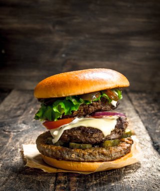 Büyük burger sığır eti, domates ve yeşillik.