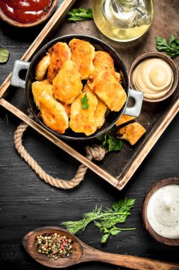 Nuggets tavuk eti bir tepsi üzerinde soslar ile gelen.
