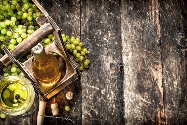 Wine background. White wine on a stand with branches of fresh grapes.