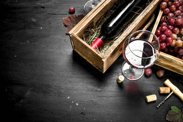Винный фон. Красное вино в старой коробке с штопором . — стоковое фото