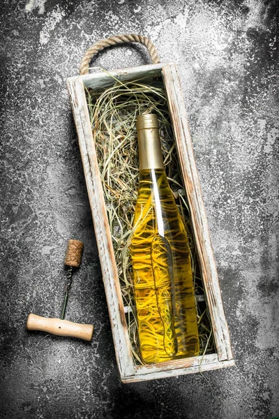 Wine background. A bottle of white wine in an old box.