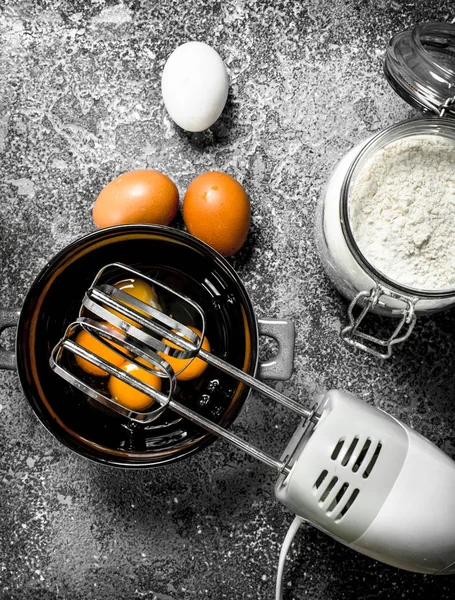 Fondo para hornear. Mezclar los huevos con una batidora para hacer una masa . — Foto de Stock