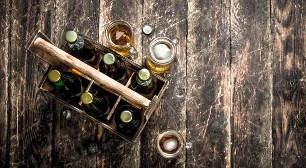 Garrafas com cerveja em uma caixa velha . — Fotografia de Stock