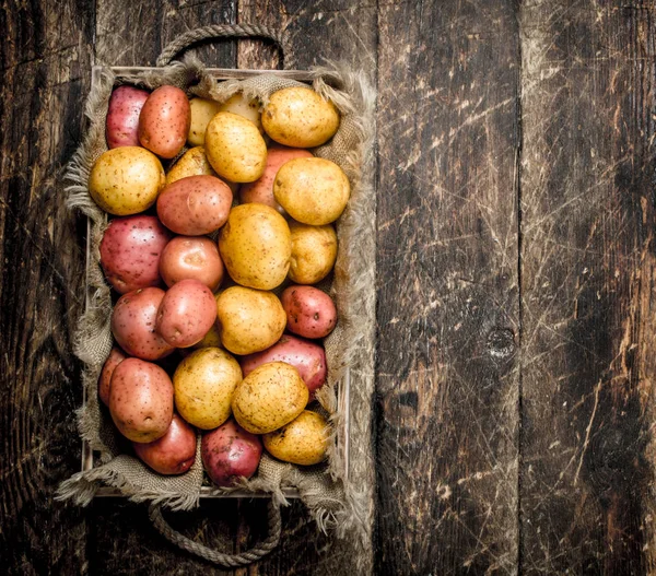 Frische Kartoffeln auf einem Holztablett. — Stockfoto