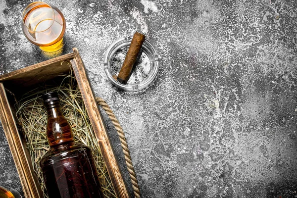 Bottle of cognac in an old box with a cigar. — Stock Photo, Image