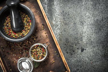 Bir havan topu bir ahşap tepsi içinde biber.