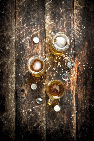 Birra fresca in un bicchiere con tappi e apribottiglie . — Foto Stock