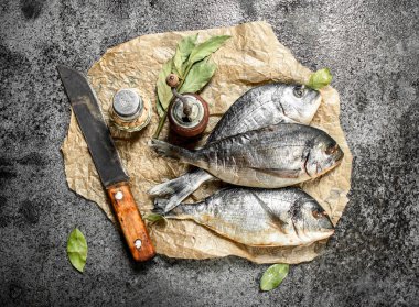 Eski bir bıçak ve baharat ile taze Dorado balık.