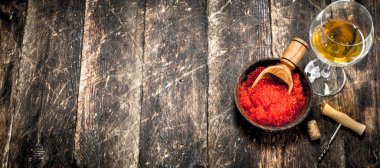 Bir kadeh beyaz şarap ile bir kase kırmızı havyar.