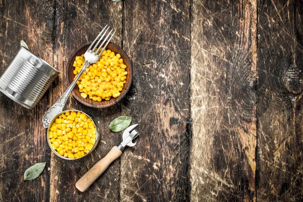 Canned corn in a tin can with opener.