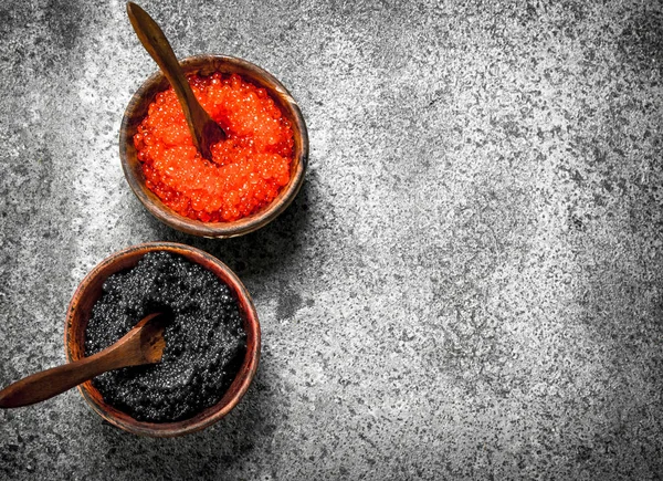 Caviar vermelho e preto em tigelas de madeira . — Fotografia de Stock