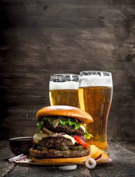 Street food. A big burger with glasses of light beer.